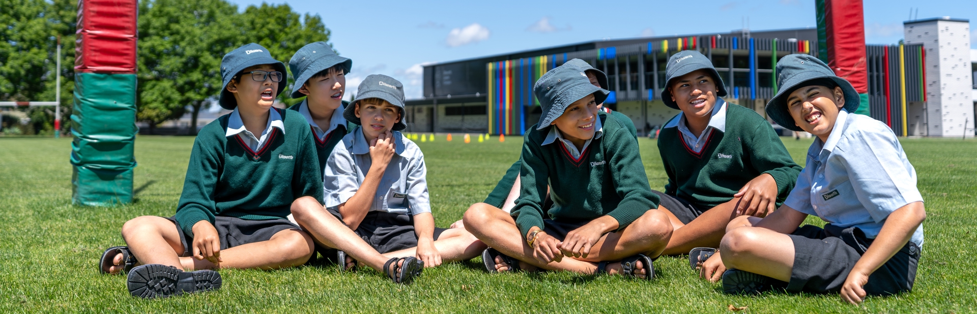 boys sitting on a rugby field under goal posts
